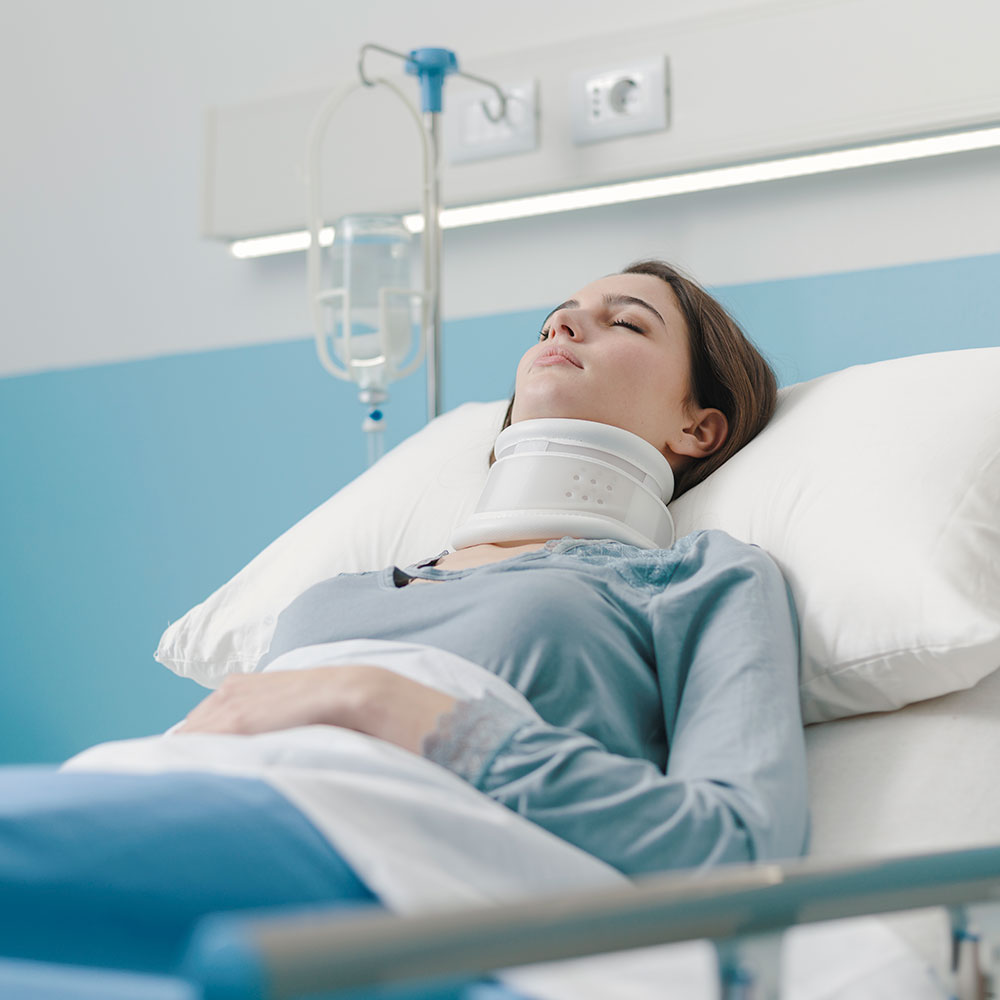 A woman laying on a hospital bed wearing a neck brace