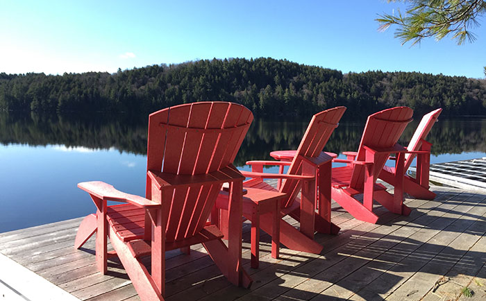 Muskoka chairs sitting on lakeside dock